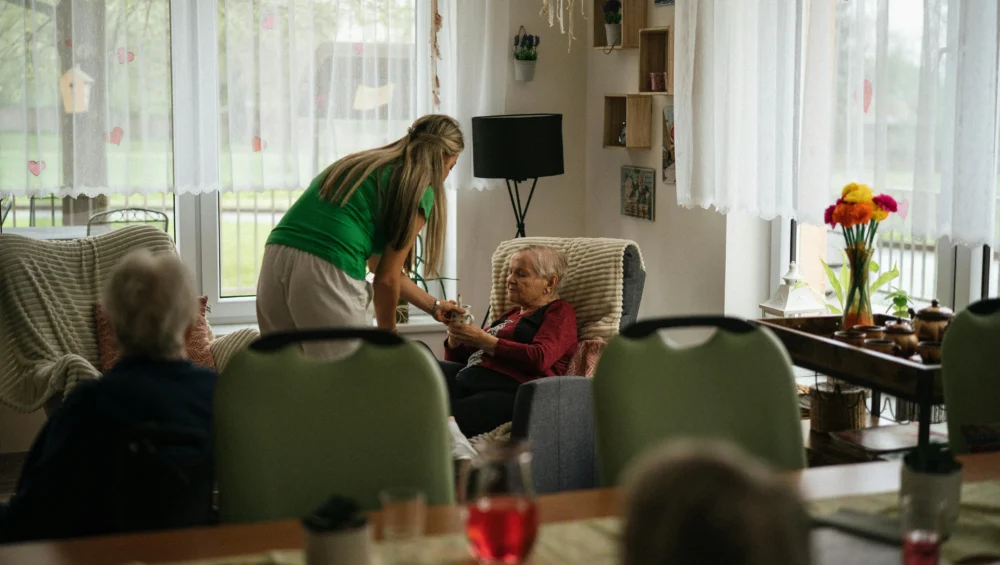 senior woman caregiver talking living room