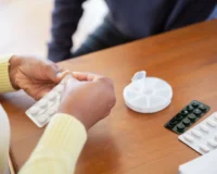 woman handling medicine at the table